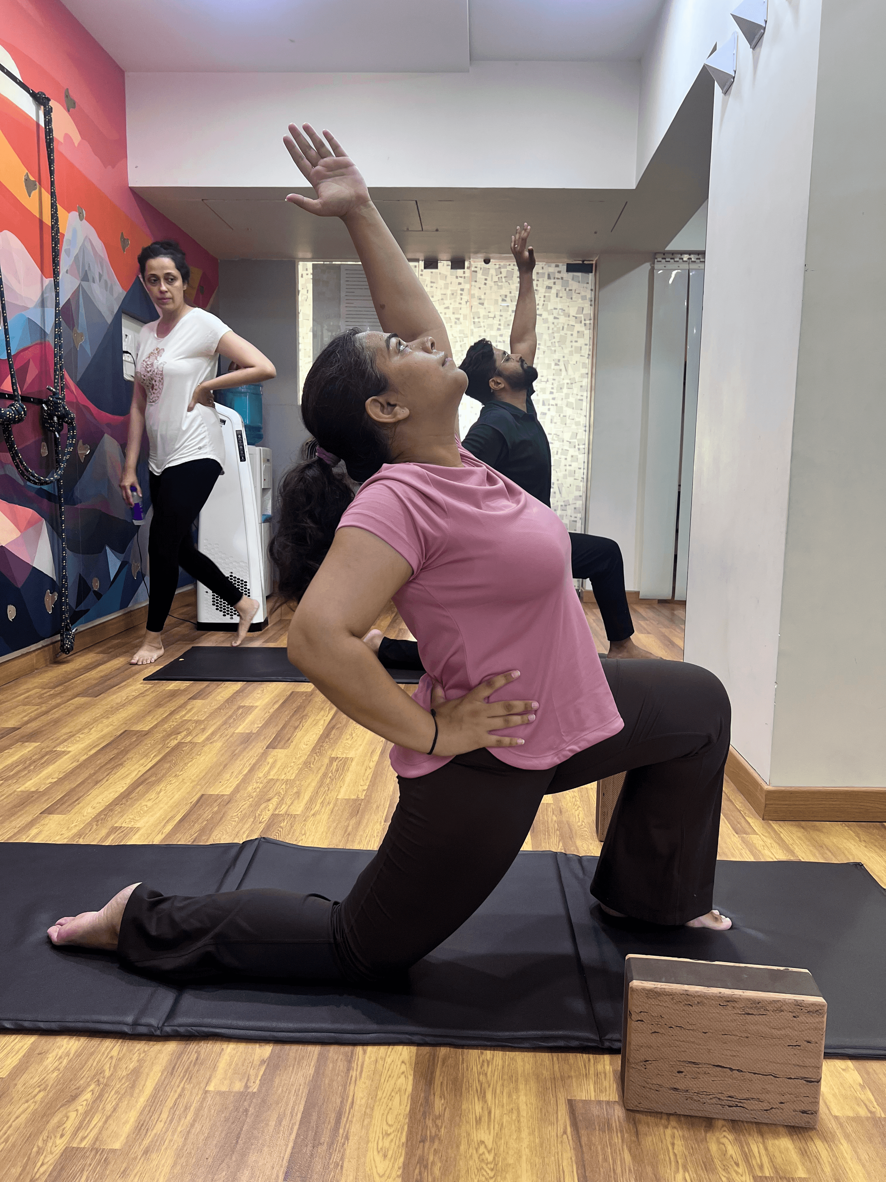 Yoga student doing a low lunge with an arm reach for side stretching