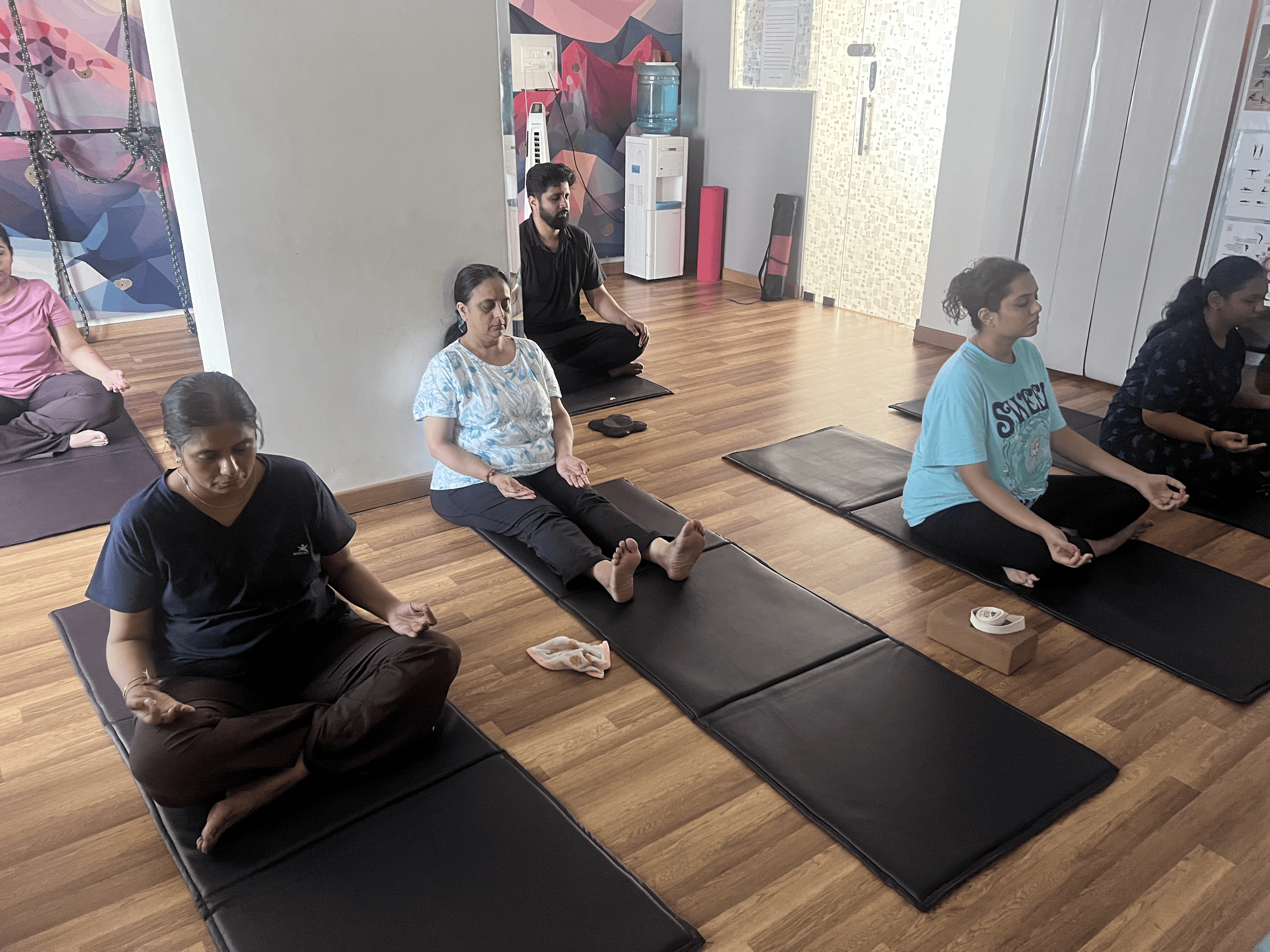 Students practicing seated pranayama and breathwork with closed eyes