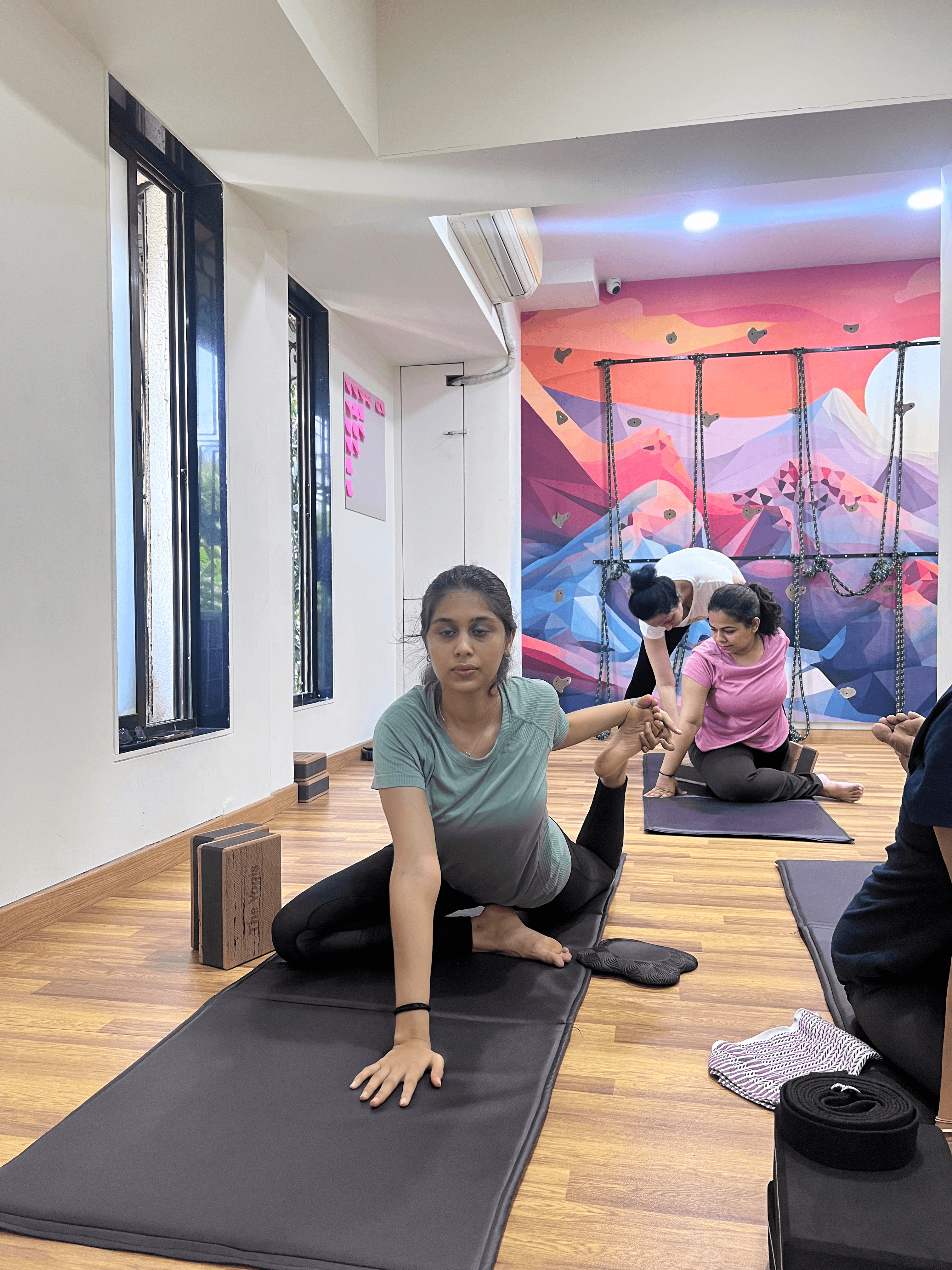 Wall rope yoga practice under Mayuri's adjustment guidance